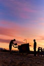 An evening silhouette of a vendor and his grill cart on the beach. Evening market on the beach Royalty Free Stock Photo