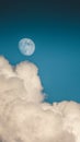 Evening sky with clouds and bright partial moon. Nightsky with large moon, nature background. Vertical photo