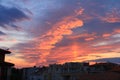 Evening sky with colorful clouds and the silhouette of the city below.