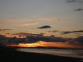 Evening sky with dark rainclouds and fiery sunlight reflections at Findhorn Bay, Scotland Royalty Free Stock Photo