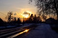 Evening sky with golden clouds over the village road with highlights from the sun rays  rural winter landscape Royalty Free Stock Photo