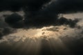 In the evening sky through the rain clouds the sun peeps out. From the sun the sun`s rays diverge. Royalty Free Stock Photo