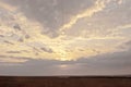 .Summer. Evening. Sunset in the field. Sky in the clouds. The sun shines from behind the clouds Royalty Free Stock Photo