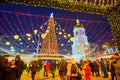 Evening on Sophia Square with a view on decorative gate of the Christmas Fair with tall and richly decorated main Christmas Tree