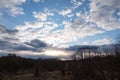 Evening spring blue sky with white clouds. Dark silhouettes of trees and shrubs. Evening landscape Royalty Free Stock Photo