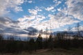 Evening spring blue sky with white clouds. Dark silhouettes of trees and shrubs. Evening landscape Royalty Free Stock Photo