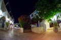 Evening street along small white houses with blue windows Royalty Free Stock Photo