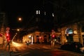 Evening street life, car and walking people and warm lights in B