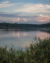 Evening summer on the lake with green reeds in the foreground. Sunset with blue and pink cumulus clouds and blue sky Royalty Free Stock Photo