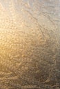 Evening sun and bright blue sky through the frost pattern on the window. Ice pattern and sunlight on winter glass Royalty Free Stock Photo