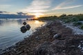 Evening sunlight on coast, pink clouds, blue sky reflection on water. Beach in summer. Seaside natural environment. Royalty Free Stock Photo