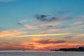 Evening sunlight on coast, pink clouds, blue sky reflection on water. Beach in summer. Seaside natural environment. Royalty Free Stock Photo