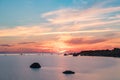 Evening sunlight on coast, pink clouds, blue sky reflection on water. Beach in summer. Seaside natural environment. Royalty Free Stock Photo