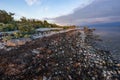 Evening sunlight on coast, pink clouds, blue sky reflection on water. Beach in summer. Seaside natural environment. Royalty Free Stock Photo