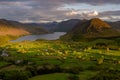 Evening sunlight shining on Cumbrian valley with moody clouds above Crummock Water. Lake District, UK. Royalty Free Stock Photo