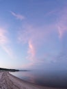 Evening sunlight and spruce tree on the coast, pink clouds and blue sky background. Beach in summer. Royalty Free Stock Photo