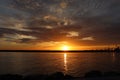 Evening sunset reflecting on the sea water and an orange cloudy sky