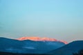 Evening sunset turns distant mountain pink as all the other mountains are in deep blue shadow looking over the Corinth Canal to Royalty Free Stock Photo