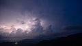 Evening thunderstorm with lightning in the mountains. Dramatic clouds during a thunderstorm pierce the light of Royalty Free Stock Photo
