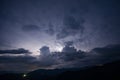 Evening thunderstorm with lightning in the mountains. Dramatic clouds during a thunderstorm pierce the light of Royalty Free Stock Photo