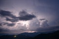 Evening thunderstorm with lightning in the mountains. Dramatic clouds during a thunderstorm pierce the light of Royalty Free Stock Photo