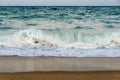 Evening tidal restless waves roll onto a sandy beach Royalty Free Stock Photo