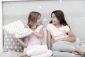 Evening time for fun. Sleepover party ideas. Girls happy best friends or siblings in cute stylish pajamas with pillows Royalty Free Stock Photo