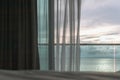 Evening time of ocean view from hotel balcony with curtains. Royalty Free Stock Photo