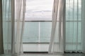 Evening time of ocean view from hotel balcony with curtains. Royalty Free Stock Photo