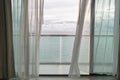 Evening time of ocean view from hotel balcony with curtains. Royalty Free Stock Photo