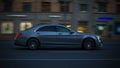Evening traffic on the city streets. Gray Mercedes-Benz W222 S-Class driving in night urban road