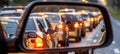 Evening traffic jam cars with headlights queuing, reflected in the rearview mirror