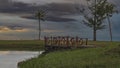 An evening in the tropics. A wooden pedestrian bridge with railings spans a small river. Royalty Free Stock Photo