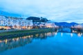 Evening twilight view of Salzburg with illuminated houses across Salzach river in Austria Royalty Free Stock Photo