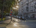 Evening view, a boy with a backpack, waiting for a pedestrian signal to cross the road