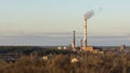 Evening view of the city, the pipes of the plant with smoke coming out of them