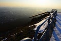 Evening view on cityscape from viewpoint hill with steel rail and old bench during snowy season. Location Nitra city, Slovakia