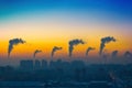 Evening view of the industrial landscape of the city with smoke emissions from chimneys at sunset. Royalty Free Stock Photo