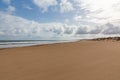 Evening view on small sand dune with green grass. Sandy beach at sea coast. Blue sky with white clouds. Sunset time