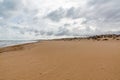 Evening view on small sand dune with green grass. Sandy beach at sea coast. Blue sky with white clouds. Sunset time