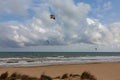 Evening view on small sand dune with green grass. Sandy beach at sea coast. Blue sky with white clouds. Sunset time