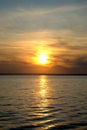 Evening view of the surface of the river and reflection of the setting sun and sky in its surface.