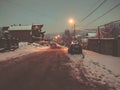 Evening view of the town, snow on the road. Trees in the snow. Mountain ski resort Bakuriani