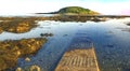 Bright evening sunshine, still, calm waters, rock pools and reef, in Looe Bay, Cornwall UK Royalty Free Stock Photo