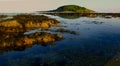 Bright evening sunshine, still, calm waters, rock pools and reef, in Looe Bay, Cornwall UK Royalty Free Stock Photo