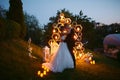 Evening wedding ceremony. The bride and Groom are on the background of the wedding arch. Royalty Free Stock Photo