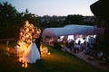 Evening wedding ceremony. The bride and Groom are on the background of the wedding arch. Royalty Free Stock Photo