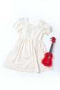 Evening white dress and little guitar flatlay