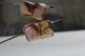 Evenly toasted marshmallows on skewer with burned texture on the surface