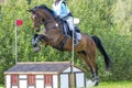 Eventing: equestrian rider jumping over an a log fence obstacle